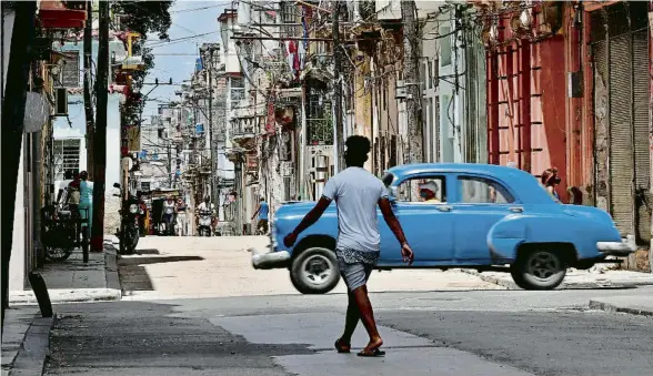  ?? ERNESTO MASTRASCUS­A / EFE ?? Un tal com es coneixen aquests cotxes de museu a Cuba, circula per un carrer de l’Havana, enmig de la calma