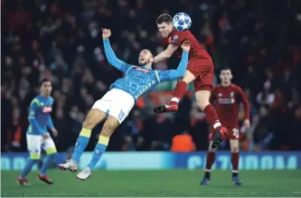  ?? CLIVE BRUNSKILL GETTY IMAGES ?? James Milner of Liverpool outjumps Nikola Maksimovic of Napoli during a UEFA Champions League Group C soccer match at Anfield on Tuesday.