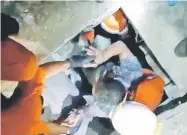  ?? — Reuters photo ?? Resucers pull a man from the Mandala Finance building after an earthquake in Palu, Sulawesi, Indonesia in this picture obtained from social media.