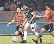  ??  ?? Muang Thong’s Teerasil Dangda, centre, during the match against Chiang Rai United.