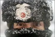  ?? JOHN MINCHILLO — THE ASSOCIATED PRESS ?? Times Square Alliance security officer Margarita Torres walks in a snowstorm Feb. 1in New York.