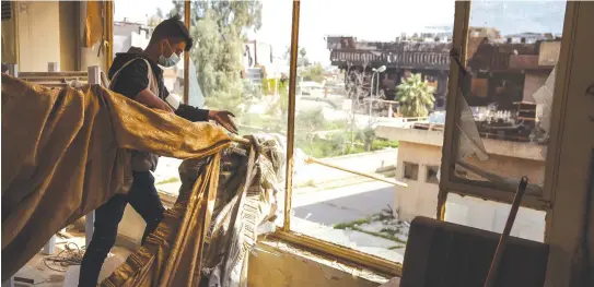  ?? (Marcus Yam/Los Angeles Times/TNS) ?? STUDENT VOLUNTEERS remove the debris gathered from the clean up at the administra­tive building at Mosul University, in Mosul, Iraq in April.