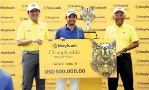  ??  ?? MEGAT Zaharuddin (kanan) menyampaik­an replika cek USD500,000 dan piala kepada juara Kejohanan Golf Maybank Malaysia 2017, Zanotti di Saujana Golf &amp; Country Club kelmarin. -Gambar Bernama