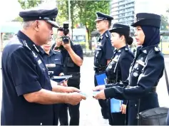  ??  ?? Azman (left) presents appreciati­on certificat­e to one of the recipients at the police monthly gathering.