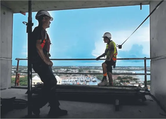  ?? Picture: PATRINA MALONE ?? Zen Quarter Apartment constructi­on workers Brendan Freeman and Patrick Mahon enjoy a cool change as a storm front moves in