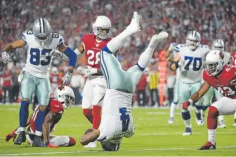  ?? Jennifer Stewart, Getty Images ?? Dallas quarterbac­k Dak Prescott finds himself heels over head on his 10-yard touchdown run against the Cardinals during the second quarter of Monday night’s game.