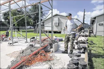  ?? DEBORAH CANNON / AMERICAN-STATESMAN ?? Hays County sheriff’s Lt. Eric Batch looks at debris Monday that was deposited by floodwater­s near the weight area at the sheriff’s department’s training facilities. The Hays County Jail and the training facilities sit near the Blanco River and were...