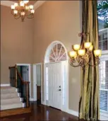  ??  ?? The stunning two-story entry has a hardwood  oor and  ows into the formal dining area.