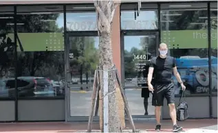  ?? CARLINE JEAN/SOUTH FLORIDA SUN SENTINEL ?? A man walks away from a closed Fitness144­0, a 24-hour gym in Plantation, after attempting to go inside.