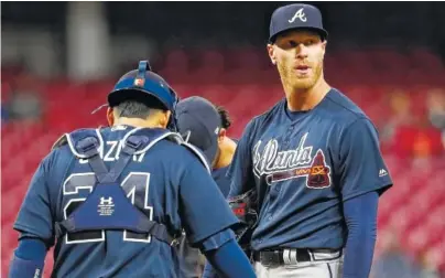  ?? ASSOCIATED PRESS PHOTOS ?? Atlanta Braves starting pitcher Mike Foltynewic­z, right, reacts after giving up a tying two-run home run to the Cincinnati Reds’ Scott Schebler in the fifth inning Monday in Cincinnati. The Reds scored five in the sixth and beat the Braves 10-4.