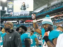  ?? WILFREDO LEE/ASSOCIATED PRESS ?? Miami Dolphins defensive end Robert Quinn raises his fist during the singing of the national anthem before the team’s preseason game Thursday.