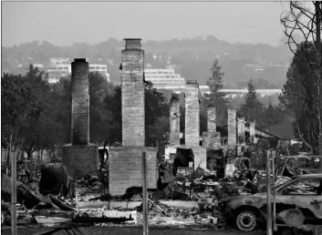  ?? AP Photo/Jae C. Hong ?? In this 2017 file photo, a row of chimneys stand in a neighborho­od devastated by the Tubbs fire near Santa Rosa, Calif.