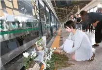  ?? Yonhap ?? A woman lays a flower at the subway platform where a young maintenanc­e worker died after being hit by a train one year ago, in Guui Station, Seoul, Sunday.