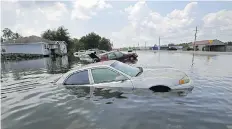  ?? GERALD HERBERT/THE ASSOCIATED PRESS ?? Flooded cars sit alongside a roadway in the aftermath of hurricane Harvey, in Port Arthur, Texas.