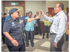  ??  ?? Causing a ruckus: Gobalakris­hnan (right) confrontin­g Sentul District police chief ACP S. Shanmugamo­orthy at the Kuala Lumpur High Court.