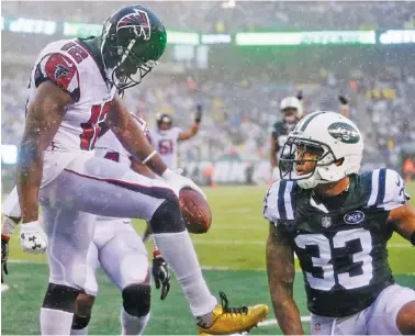  ?? THE ASSOCIATED PRESS PHOTOS ?? Atlanta wide receiver Mohamed Sanu, with ball, celebrates after making a touchdown catch as New York Jets strong safety Jamal Adams, right, looks on during the second half of the Falcons’ 25-20 win Sunday in East Rutherford, N.J.