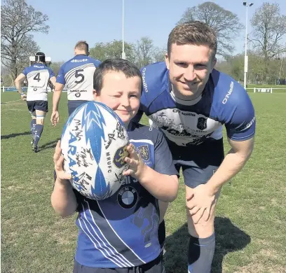  ??  ?? Mascot Kieran Carrol, U8s mini rugby player, pictured with Blues skipper