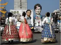  ?? KIM KYUNG-HOON/REUTERS ?? MANFAATKAN MOMEN: Turis berpakaian khas Korsel, hanbok, mengambil foto patung mantan Presiden Korsel Park Geun-hye di Seoul.