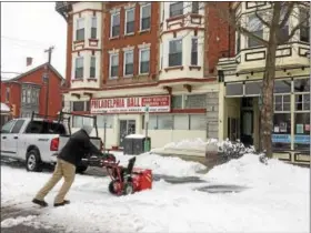  ?? EVAN BRANDT — DIGITAL FIRST MEDIA ?? Ben Moyer clears parking spaces in front of his two businesses on High Street Tuesday. “We’re open for business,” he said.