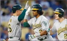  ?? ALLEN J. SCHABEN/TRIBUNE NEWS SERVICE ?? The Athletics' Mark Canha, right, and Matt Chapman, left, celebrate with Khris Davis after his 2-run HR vs. the Dodgers in Los Angeles on Wednesday.