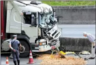  ?? AP/ANDRE PENNER ?? A man looks at wreckage after a helicopter crashed into the front of a cargo truck Monday during an emergency landing, on a main highway in Sao Paulo, Brazil. 66-year-old Brazilian television news anchor Ricardo Boechat and the pilot perished in the accident. Police say the truck driver suffered only minor injuries.