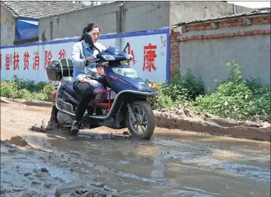  ?? ZHU LIXIN / CHINA DAILY ?? Rainfall leaves the roads in poor condition in Guhe village, Linquan county, Anhui province.