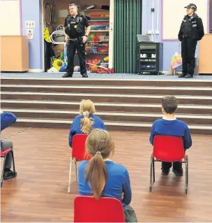  ??  ?? PC Neil Gregson and PCSO Beth Thompson during their talk to pupils at St Mary’s RC Primary and Nursery, Bacup