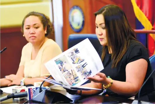  ?? (SUN.STAR FOTO/ALLAN CUIZON) ?? REPORT. Mandaue City Chief of Staff Atty. Mae Elaine Bathan (right) goes over the documents on the implementa­tion of the anti-plastic ordinance during a press conference. With her is Arch. Araceli Barlam (left), head of the Mandaue City Environmen­t and...