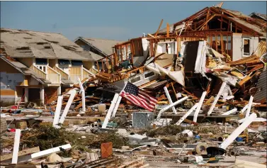  ?? REUTERS ?? An American flag flies amongst rubble left in the aftermath of Hurricane Michael in Mexico Beach, Florida, US on Thursday. Michael crashed ashore near the beach on Wednesday afternoon, with winds of up to 155 mph. It pushed a wall of seawater inland, causing widespread flooding.