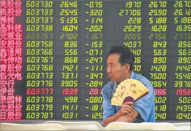  ?? AFP ?? ACALORADO. Un inversor supervisa los precios de las acciones en el centro financiero de Beijing.