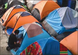  ?? PATRICK T. FALLON/AFP VIA GETTY IMAGES ?? Families with children live in tents at the Movimiento Juventud 2000 shelter in Tijuana on April 9, where refugee migrants from Central and South American countries including Honduras and Haiti await while seeking asylum in the United States.