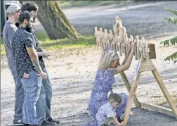  ??  ?? UNSPEAKABL­E GRIEF: A woman with a child mourns Tuesday at the makeshift memorial erected near the site of Saturday’s limo crash.