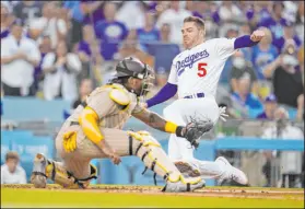 ?? Marcio Jose Sanchez The Associated Press ?? Freddie Freeman scores past Padres catcher Luis Campusano in the Dodgers’ 12-1 home victory Saturday. Freeman went 3-for-3.