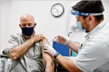  ?? THOM BRIDGE/INDEPENDEN­T RECORD (HELENA, MONTANA) ?? Montana Gov. Greg Gianforte gets the Pfizer vaccine Thursday from pharmacist Drew Garton at a Walgreens in Helena, Montana.