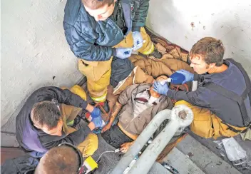  ??  ?? Manchester, N.H., firefighte­rs try to revive a man who overdosed in a building’s stairwell.