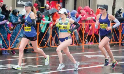  ?? Photograph: Scott Eisen/Getty Images ?? Nicole Dimercurio, Rachel Hyland and Sarah Sellers approach the 24 mile marker of the 2018 Boston marathon, defying rainy conditions, on16 April 2018 in Brookline, Massachuse­tts.