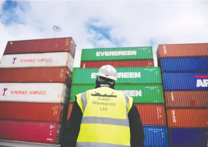  ?? AIDAN CRAWLEY/BLOOMBERG FILES ?? Shipping containers are unloaded at a Dublin port. Once overwhelmi­ngly dependent on the United Kingdom, Ireland abruptly changed course and opened itself up, opting to focus on foreign direct investment, building export industries and mapping new trade routes. It is continuing to drum up more business as a consequenc­e of Brexit.