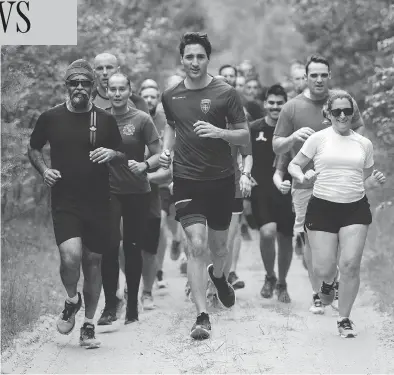  ?? SEAN KILPATRICK/THE CANADIAN PRESS ?? Prime Minister Justin Trudeau, Defence Minister Harjit Singh Sajjan and Foreign Affairs Minister Chrystia Freeland go for an early jog with troops at Adazi Military Base in Kadaga, Latvia, on Tuesday.