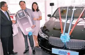  ??  ?? RHB Banking Group retail banking acting head Nazri Othman (left) congratula­ting Johor Baru businessma­n Tan Huat Soon, 62, and his wife Cao Jinlin, for winning a BMW 730Li worth RM600,000 as the Grand Prize of RHB Bank’s “Drive Home A BMW Series”...