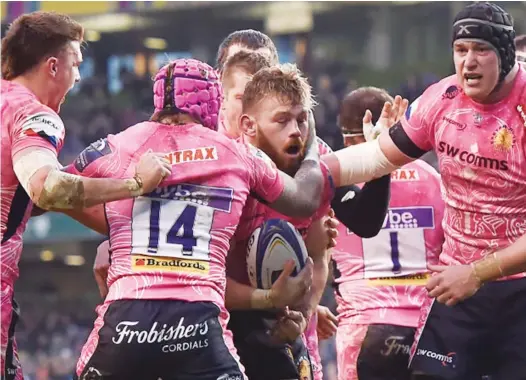  ??  ?? Force of nature: Luke Cowan-Dickie, centre, is congratula­ted after scoring Exeter’s second try