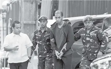  ??  ?? Labidi Adib (centre) is escorted by Philippine soldiers as he arrives at the Department of Justice building in Manila. — AFP photo