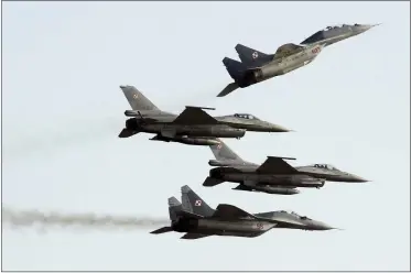  ?? ALIK KEPLICZ/ASSOCIATED PRESS ?? Two Polish Air Force Russian made Mig 29’s fly above and below two Polish Air Force U.S. made F-16’s fighter jets during the Air Show in Radom, Poland, on Aug. 27, 2011. In a private video call with American lawmakers over the weekend, Ukrainian President Volodymyr Zelenskyy made a “desperate” plea to the United States to help Kyiv get more warplanes to fight Russia’s invasion and retain control of its airspace.