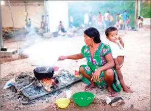  ?? AFP ?? A member of the Warao tribe, Venezuela’s second-largest indigenous group, prepares food at the Janokoida shelter in the Brazilian border city of Pacaraima on August 21.