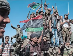  ?? MAURICIO LIMA NEW ?? Anti-Gadhafi fighters celebrate atop a tank after taking control of the town of Sirte, Libya, Oct. 20, 2011. After the entry of Russia and Turkey into the conflict, Germany will host a gathering on Sunday, Jan. 19, 2020, to try to persuade warring factions — and their influentia­l patrons — to give Libyans the space to attempt to find some kind of political reconcilia­tion.