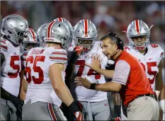  ?? AP Photo/Sue oGrocKI ?? In this 2016, file photo, Ohio State head coach Urban Meyer talks with his players in the fourth quarter of an NCAA college football game against Oklahoma, in Norman, Okla.