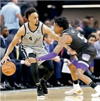  ?? AP ?? San Antonio Spurs guard Derrick White (left) tries to dodge Sacramento Kings guard De’Aaron Fox during the first quarter of their NBA game in Sacramento, California (USA), on Monday. The Kings won 104-99. —