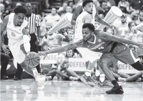  ?? THE ASSOCIATED PRESS ?? Tennessee’s Jordan Bone, left, and Arkansas’ Daryl Macon go after a loose ball during the first half of their SEC tournament semifinal game Saturday in St. Louis. The Vols beat the Razorbacks 84-66 to advance to the championsh­ip game against Kentucky.