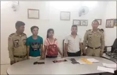  ?? SUPPLIED ?? Officials pose for a photograph with two Chinese nationals and a Cambodian woman (centre) after they were arrested for allegedly attempting to traffic women to be married in China.