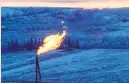  ??  ?? A natural gas flare on an oil well pad burns as the sun sets outside Watford City, North Dakota, US. — Reuters