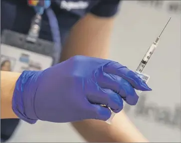  ?? Brian van der Brug Los Angeles Times ?? A NURSE readies a dose of a COVID-19 vaccine. An experiment­al vaccine could prepare for new variants by priming the immune system to recognize the coronaviru­s’ more stable viral protein as well as its spike protein.